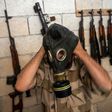 A rebel tries on a gas mask seized from a Syrian army factory in the north-western province of Idlib