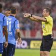 German referee Tobias Stieler gestures for the video assistant referee to review a decision during the Bundesliga match between Bayern Munich and Bayern Leverkusen on August 18, 2017