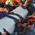Migrants cling to a boat during a rescue operation off the Libyan coast in November 2016
