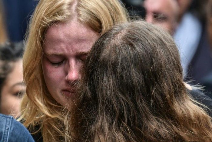 Friends of Frenchwoman Julie Huynh mourn at the country's embassy in Bogota during a homage to her and two other women killed in a bombing at a mall