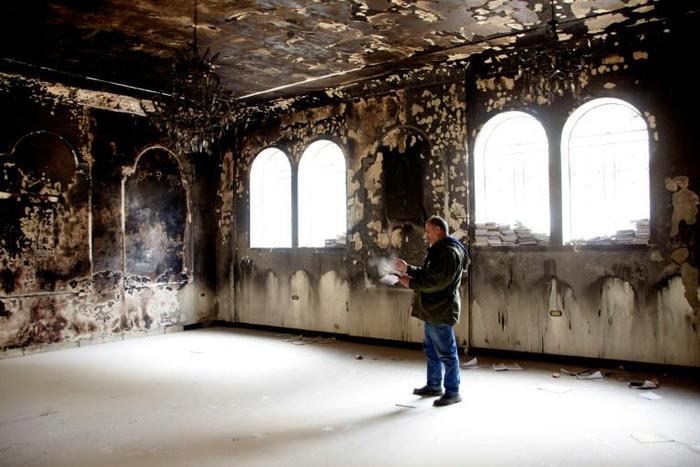 Nabil al-Aash inspects the war-scarred Saint George Church, a testament to the seven-year conflict that has left more than 360,000 people dead