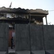 An Afghan security personnel stands at the entrance of the Iraqi embassy building after an attack in Kabul on Monday