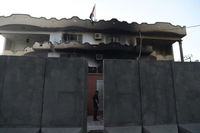 An Afghan security personnel stands at the entrance of the Iraqi embassy building after an attack in Kabul on Monday