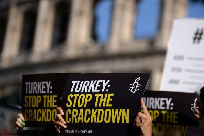 Amnesty International activists hold placards as they protest against the arrest of rights activists in Turkey, including Amnesty International's Turkey director, on July 20, 2017, near the Coliseum in Rome