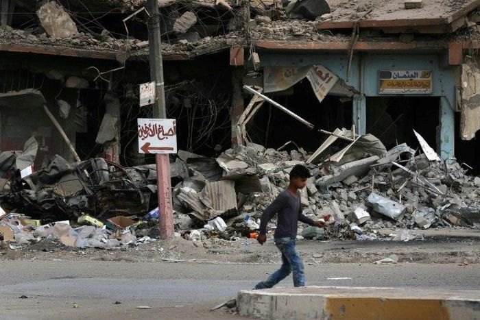 A boy walks along a damaged street in west Mosul on July 13, 2017, a few days after the government's announcement of the "liberation" of the city from the Islamic State group