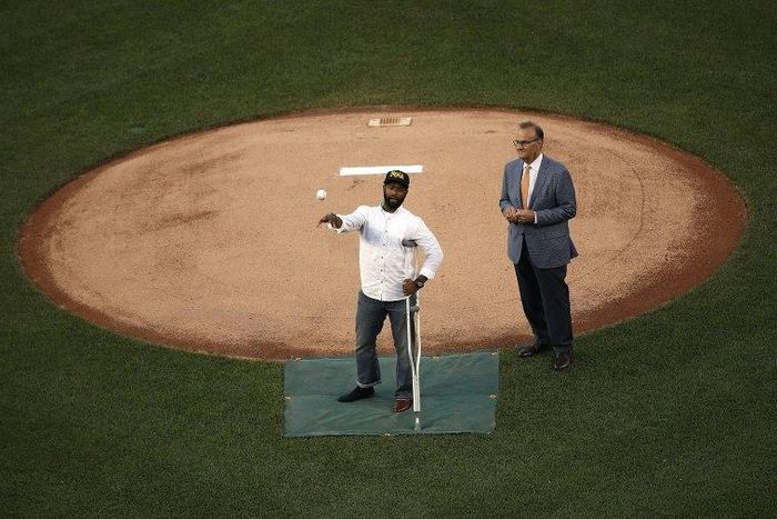 U.S. Capitol Hill special agent David Bailey (L), who was wounded in yesterday's shooting, throws out the first pitch at the Congressional Baseball Game in Washington, DC