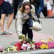 A woman lays a bouquet of flowers at a pedestrian crossing by Borough market following attacks which left eight people dead
