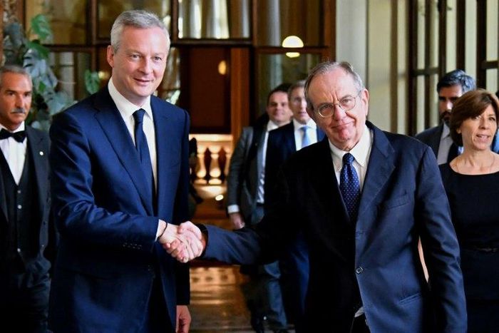 Italy's Minister of the Economy and Finance Pier Carlo Padoan (R) shakes hands with his French counterpart Bruno Le Maire in Rome on August 1, 2017