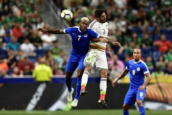 Curacao's midfielder Leandro Bacuna (L) and Mexico's defender Jair Pereira (C) jump for the ball as Curacao's forward Gino van Kessel watches (R) during the second half of their CONCACAF Gold Cup match at the Alamodome in San Antonio, Texas