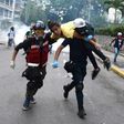 An injured opposition activist is taken away by volunteer medics during a protest against the government of President Nicolas Maduro in Caracas on July 1