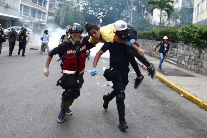 An injured opposition activist is taken away by volunteer medics during a protest against the government of President Nicolas Maduro in Caracas on July 1