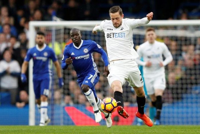 Swansea City's midfielder Gylfi Sigurdsson (C) runs forward with the ball during the English Premier League football match against Chelsea February 25, 2017
