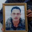 Walid Amri, brother of alleged Berlin Christmas market attacker Anis Amri, holds a portrait of his brother outside the family house in Oueslatia on December 23, 2016
