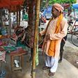 An Indian Hindu Sadhu (holy man) collecting alms with a sacred cow blesses a resident in New Delhi
