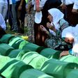 Bosnian women offers prayers near the caskets of 71 victims of the 1995 Srebrenica massacre, at the memorial cemetery in the village of Potocari on July 11, 2017