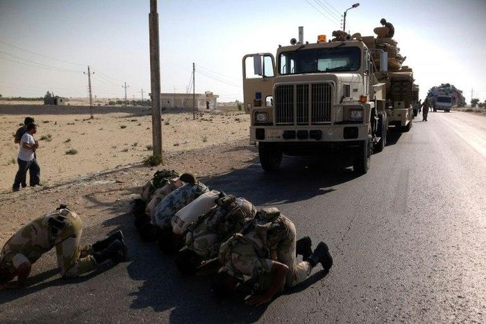 Egyptian soldiers pray as they are deployed in the North Sinai town of El-Arish on July 16, 2013