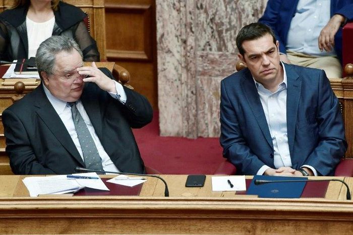 Greek prime minister Alexis Tsipras (R) and Greek foreign minister Nikos Kotzias look on during a debate on recent Cyprus talks on July 11, 2017 at the Greek parliament in Athens