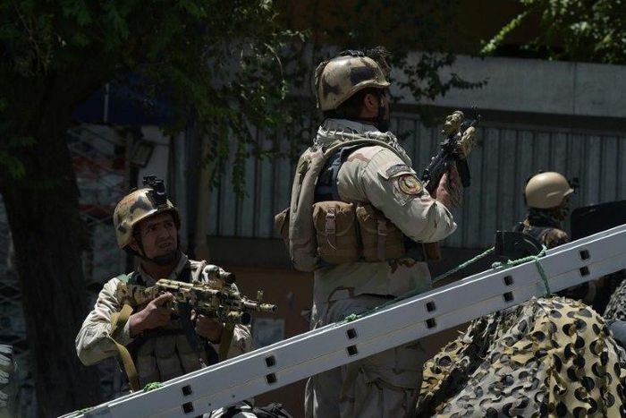 Afghan security forces stand guard at the site of a suicide blast near Iraq's embassy in Kabul