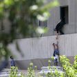 Iranian policemen evacuate a child from the parliament building in Tehran on June 7, 2017 during an attack on the complex