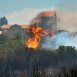 A forest fire consumes vegetation next to a monastery on the Lustica peninsula near the town of Tivat, Montenegro, on July 17, 2017