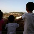 Children from the Palestinian village of Deir Ibzi in the Israeli-occupied West Bank look at the Jewish settlement of Dolev on May 10, 2017