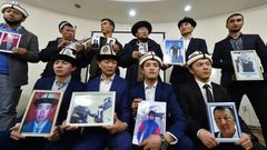 Kyrgyz family members hold portraits of their relatives who they fear are being held in notorious "re-education camps" in China's Xinjiang region