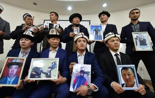 Kyrgyz family members hold portraits of their relatives who they fear are being held in notorious "re-education camps" in China's Xinjiang region