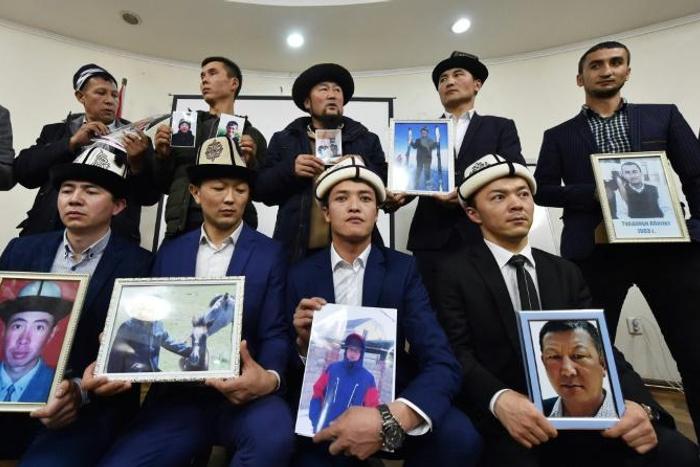 Kyrgyz family members hold portraits of their relatives who they fear are being held in notorious "re-education camps" in China's Xinjiang region