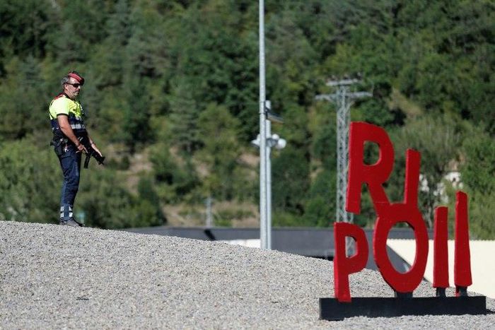 A police officer stands guard at a roadblock near the small Catalan town of Ripoll as part of a manhunt for suspects in the Barcelona and Cambrils attacks