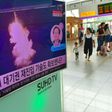 This file photo from August 25, 2016 shows people walking past a television screen at a railway station in Seoul reporting news of a North Korean submarine-launched ballistic missile test