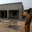 A Pakistani villager poses as he points to a house where a teenage girl was raped in the neighbourhood of Raja Ram in Muzaffarabad, a suburb of the central city of Multan