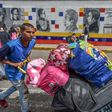 Thousands of Venezuelans, many hauling overloaded suitcases, cross the border into Colombia to escape unrest and penury at home