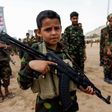 A Yemeni boy poses with a Kalashnikov assault rifle during a gathering of newly-recruited Huthi fighters in the capital Sanaa. A new UN report has flagged the vulnerability of children living in war zones mobilize more fighters to battlefronts in the w...
