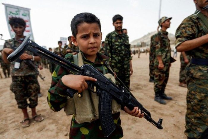 A Yemeni boy poses with a Kalashnikov assault rifle during a gathering of newly-recruited Huthi fighters in the capital Sanaa. A new UN report has flagged the vulnerability of children living in war zones mobilize more fighters to battlefronts in the w...