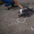 A relative places a candle beside the pool of dried blood where Mexican journalist Candido Rios was killed in Hueyapan de Ocampo, Veracruz state -- he was the 10th journalist murdered in Mexico this year