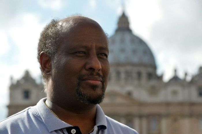 Eritrean priest Mussie Zerai poses in front of Saint Peter's basilica on October 4, 2015 in Vatican