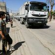 A young injured Syrian looks at United Nations and Syrian Arab Red Crescent convoy trucks arriving in the rebel-held town of Nashabiyah in eastern Ghouta on July 30, 2017 to deliver aid packages for the first time in five years