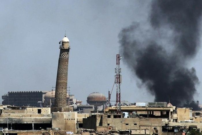 Smoke billows behind the emblemati Al-Nuri mosque in Mosul's Old City, where Iraqi forces have launched an assault on the Islamic State group