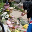 A woman places flowers at a makeshift memorial in Minneapolis, Minnesota to Justine Damond, an Australian woman shot to death by police Nancy Coune, administrator of the Lake Harriet Spiritual Community centre, places flowers and signs memorializing