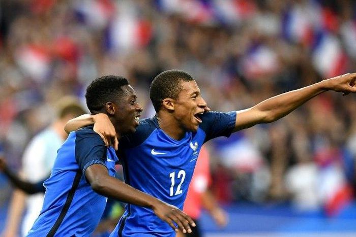 France's forward Ousmane Dembele (L) is congratulated by France's midfielder Kylian Mbappe following his goal during the international friendly football match against England at the Stade de France stadium June 13, 2017
