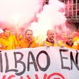 Bilbao's dockers hold a banner with flares in background during a two-day strike at the Port of Bilbao, in the Spanish Basque city of Santurtzi on June 15, 2017