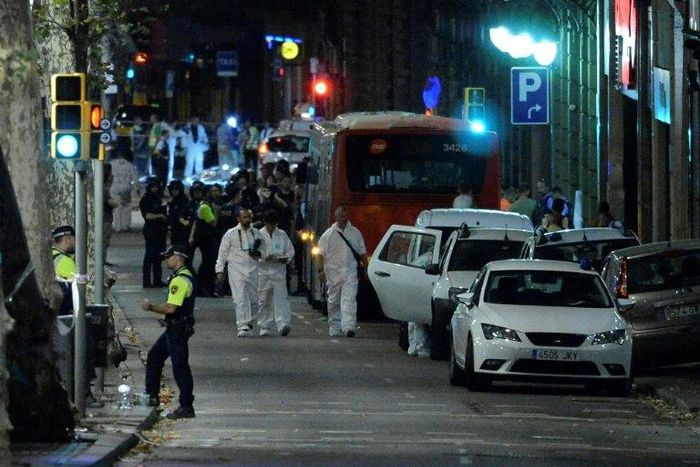 Forensic policemen arrive in the cordoned off area on Las Ramblas in Barcelona on August 17, 2017 after a van ploughed into the crowd, killing 13 people and injuring over 80