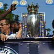 Leicester City owner Vichai Srivaddhanaprabha (L) and his son and vice-chairman Aiyawatt "Top" Srivaddhanaprabha flank the Premier League trophy the team won last season