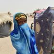 A girl hides herself next to a makeshift tent in a camp in the village of Kidjendi near Diffa, Niger on June 19, 2016 as displaced families fled from Boko Haram attacks in Bosso