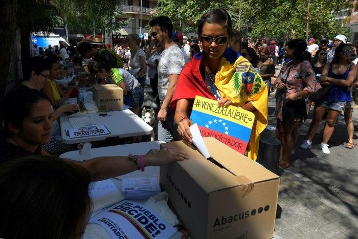 A Venezuelan resident in Barcelona casts her ballot during a symbolic plebiscite on president Maduro's project of a future constituent assembly, called by the Venezuelan opposition and held in Barcelona on July 16, 2017