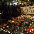 People hold a banner reading in French and Flamish "I AM BRUSSELS" as they gather around tributes for the victims of the Brussels bomb attacks March 22, 2016