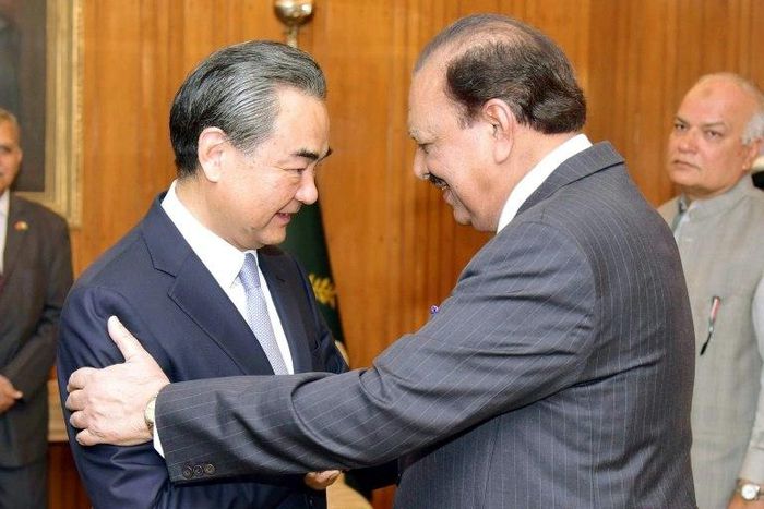 Pakistani President Mamnoon Hussain (R) shakes hands with Chinese Foreign Minister Wang Yi upon his arrival in Islamabad