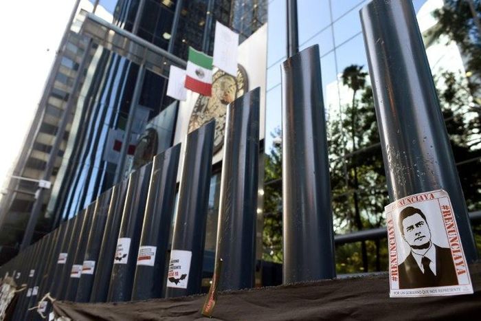 Stickers with the image of Mexican President Enrique Pena Nieto are stuck on columns outside the building of the attorney general's office during a protest against alleged government spying on journalists and human rights defenders in Mexico City last ...