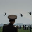 A North Korean soldier watches as Hughes MD-500 helicopters perform a fly-by during the first Wonsan Air Show in September 2016