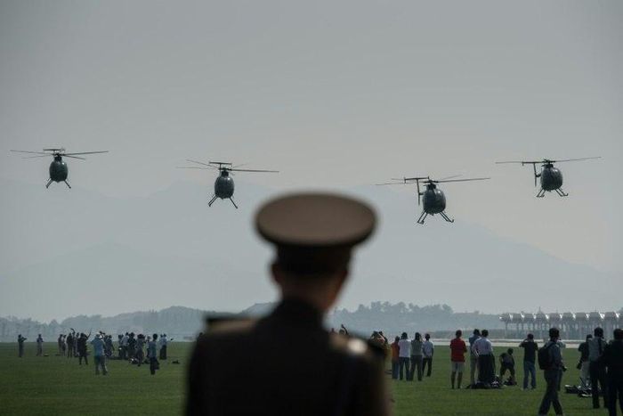 A North Korean soldier watches as Hughes MD-500 helicopters perform a fly-by during the first Wonsan Air Show in September 2016